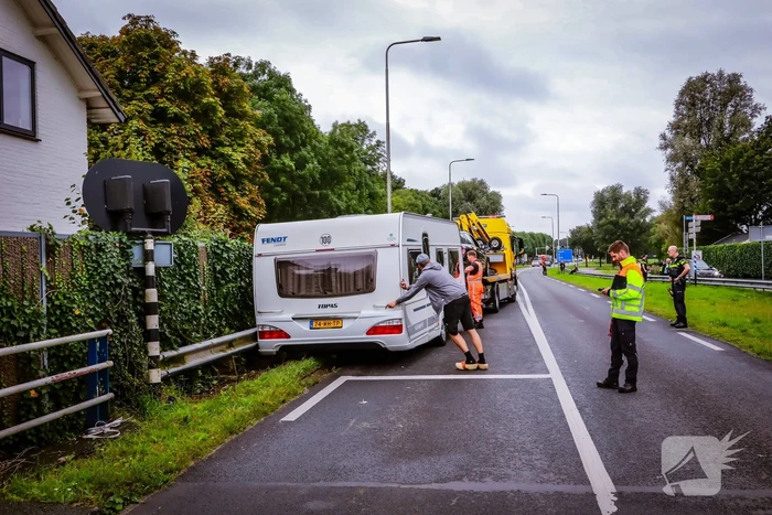 Auto met caravan belandt aan andere kant van weg