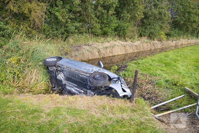 Omstanders halen automobilist uit te water geraakte auto