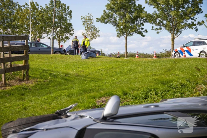 Omstanders halen automobilist uit te water geraakte auto