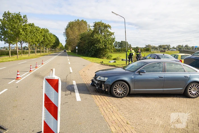 Omstanders halen automobilist uit te water geraakte auto