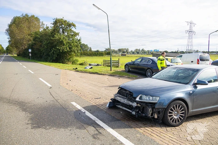 Omstanders halen automobilist uit te water geraakte auto