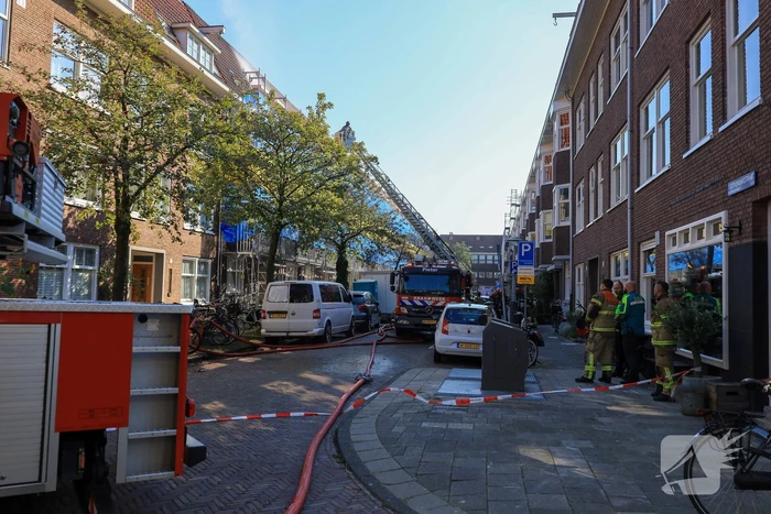 Zwarte rookwolken bij grote brand op dak van woning