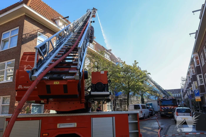 Zwarte rookwolken bij grote brand op dak van woning