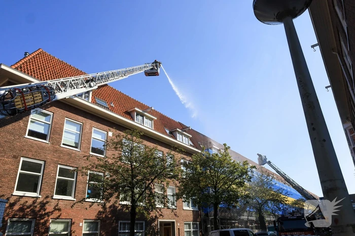 Zwarte rookwolken bij grote brand op dak van woning