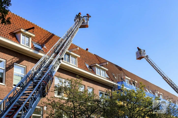 Zwarte rookwolken bij grote brand op dak van woning