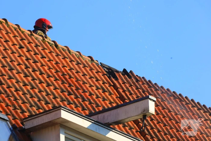 Zwarte rookwolken bij grote brand op dak van woning