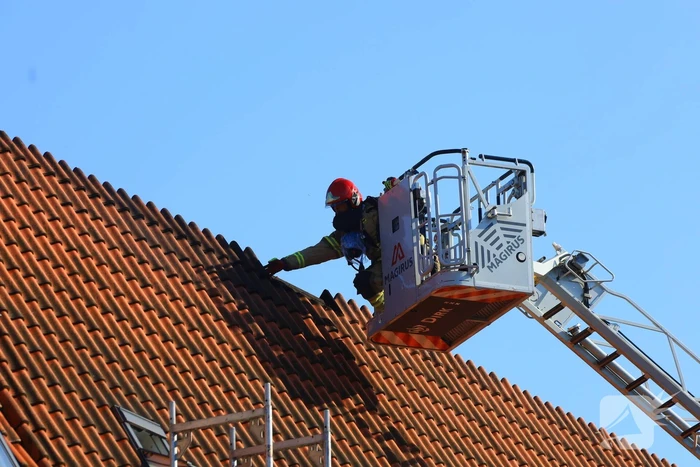 Zwarte rookwolken bij grote brand op dak van woning
