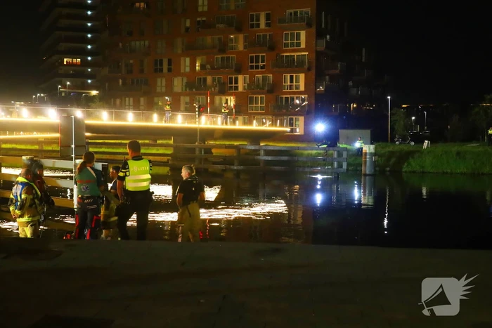 Persoon klimt op palen onder brug en word gebeten door politiehond