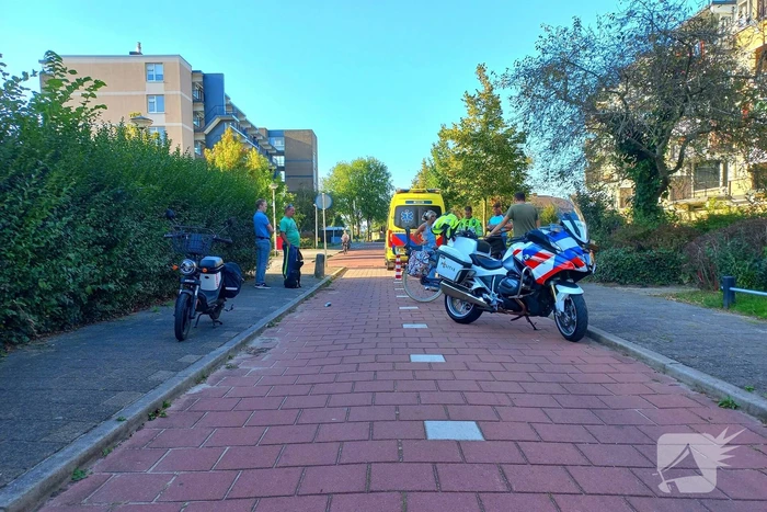 Oudere vrouw op elektrische brommer ten val