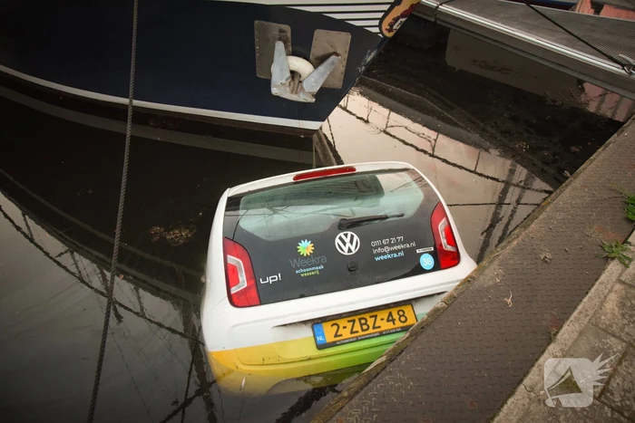 Auto rolt jachthaven in en gaat kopje onder