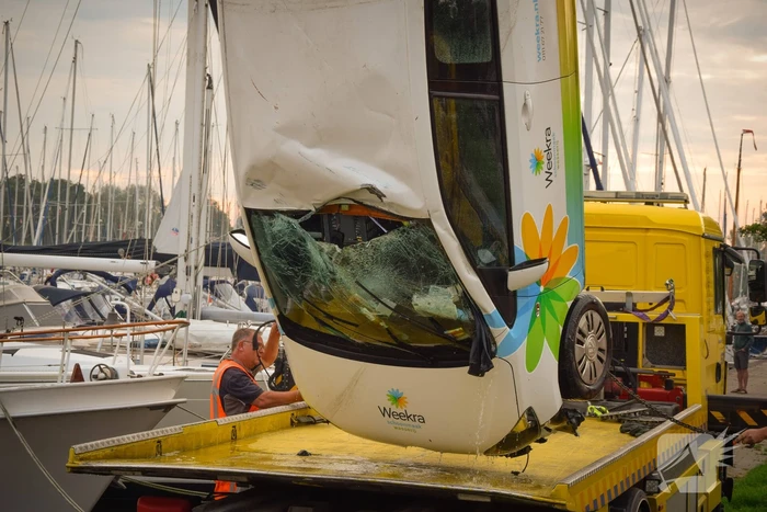 Auto rolt jachthaven in en gaat kopje onder