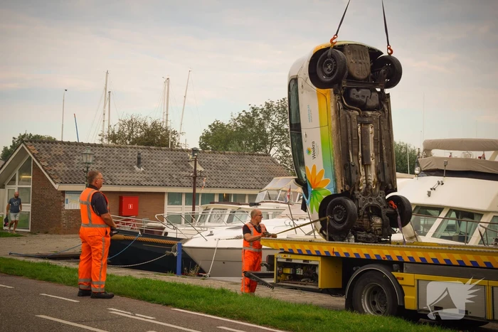 Auto rolt jachthaven in en gaat kopje onder