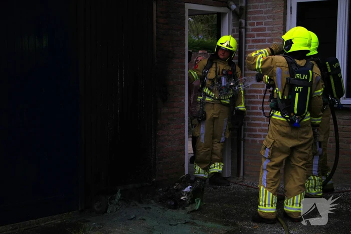 Brand in kliko slaat over op garagedeur