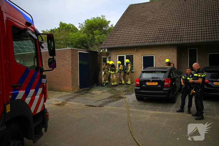 Brand in kliko slaat over op garagedeur