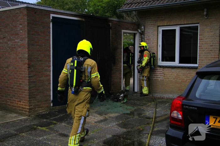 Brand in kliko slaat over op garagedeur