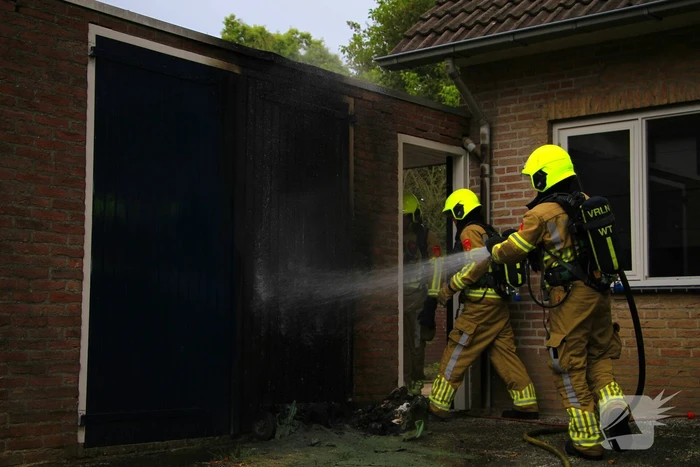 Brand in kliko slaat over op garagedeur