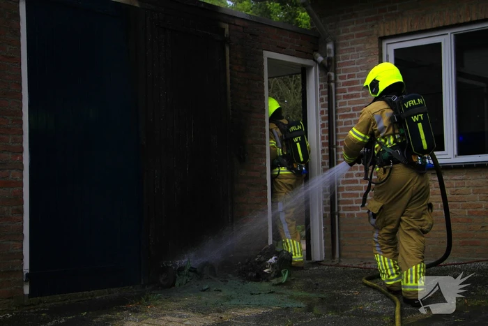 Brand in kliko slaat over op garagedeur