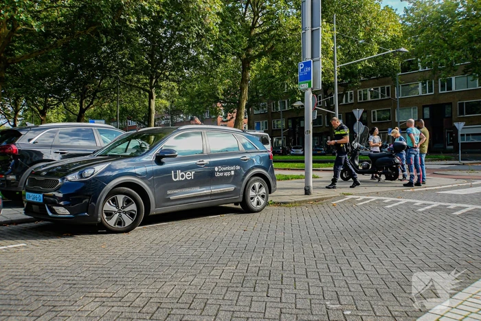 Taxichauffeur en scooterrijder in botsing