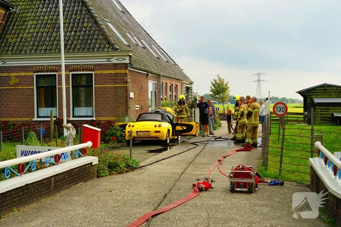 Personenwagen naast woning vliegt in brand