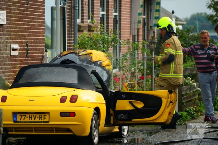 Personenwagen naast woning vliegt in brand