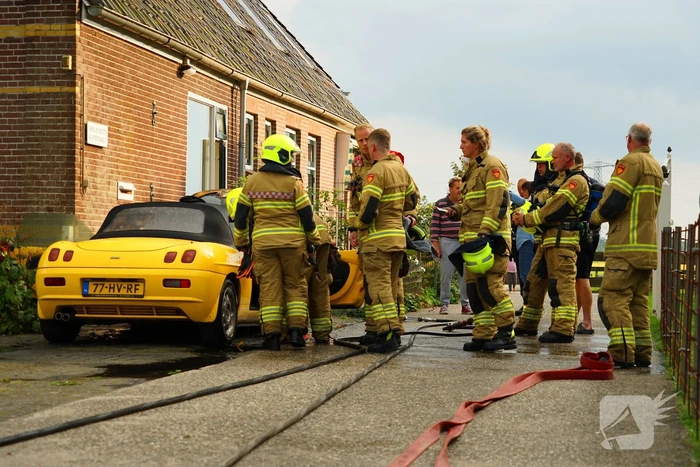 Personenwagen naast woning vliegt in brand