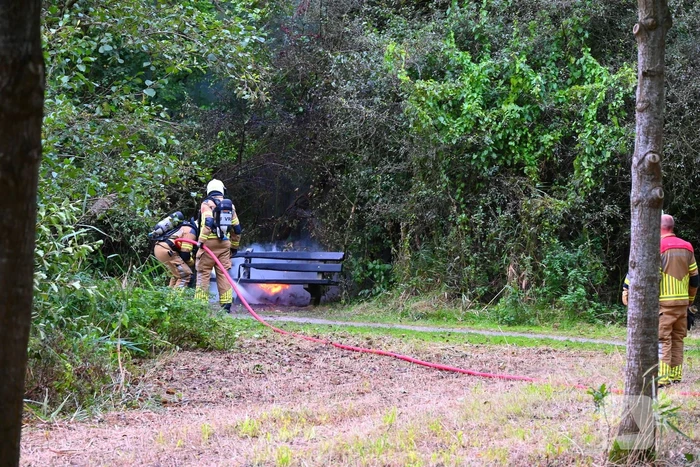 Brandweer blust brandende houten bank