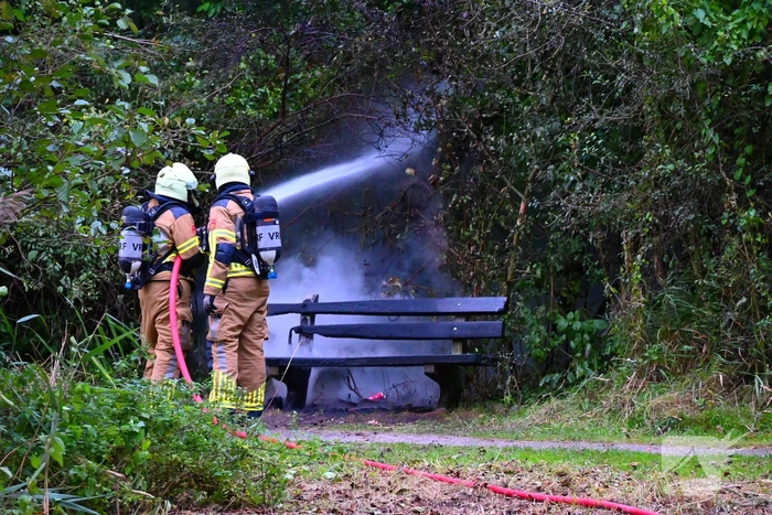 Brandweer blust brandende houten bank