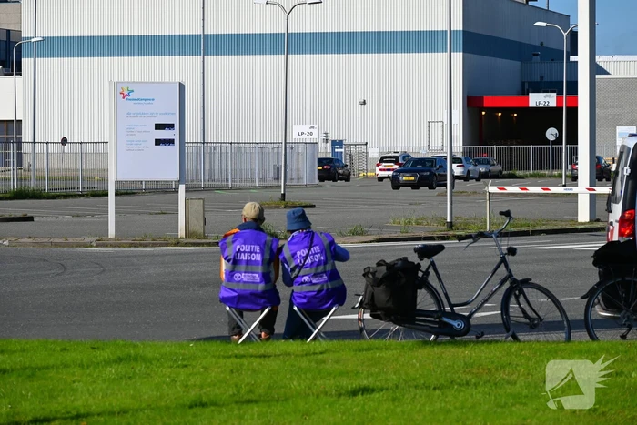 Demonstranten klimmen over hekken van zuivel fabrikant