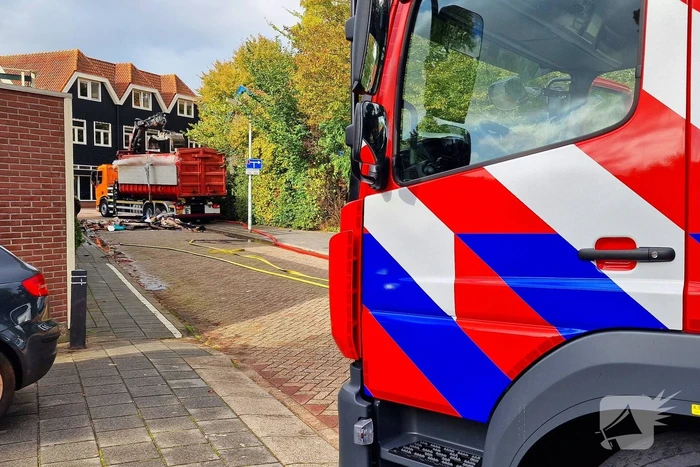 Containerwagen dumpt brandend afval op straat