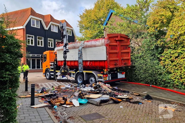 Containerwagen dumpt brandend afval op straat
