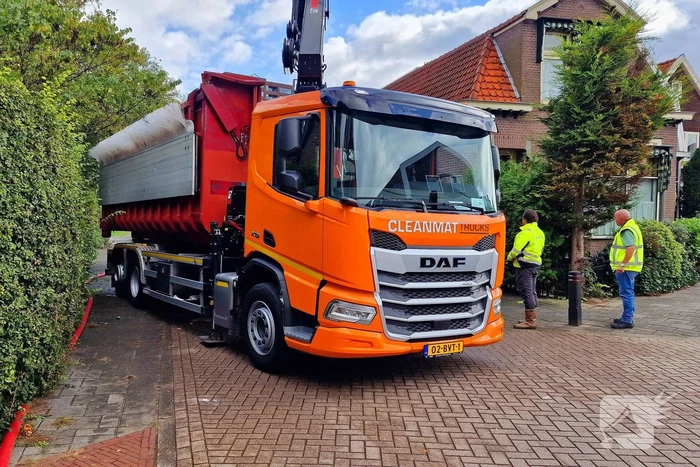Containerwagen dumpt brandend afval op straat