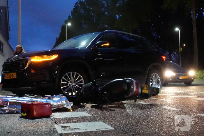 Scooterrijder klapt op personenauto