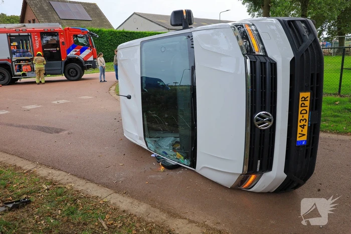 Bestelbus op zijn kant bij aanrijding