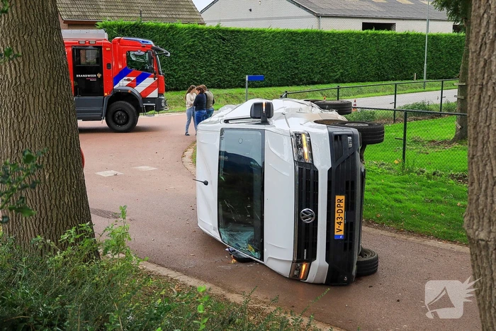 Bestelbus op zijn kant bij aanrijding