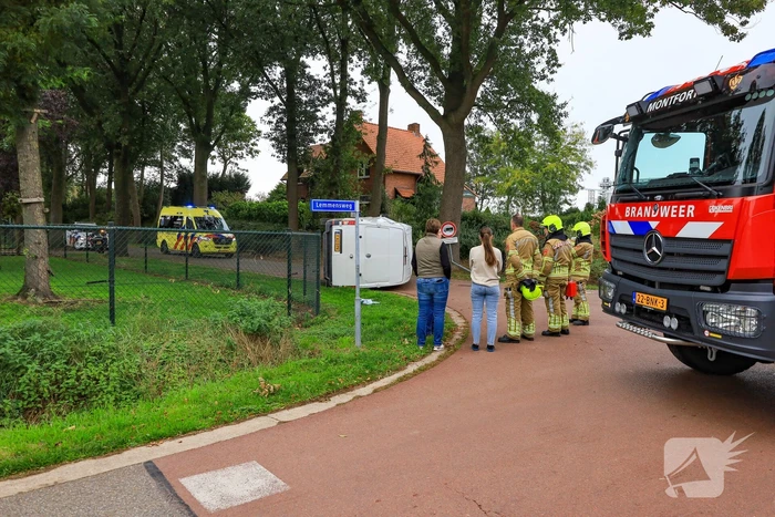 Bestelbus op zijn kant bij aanrijding
