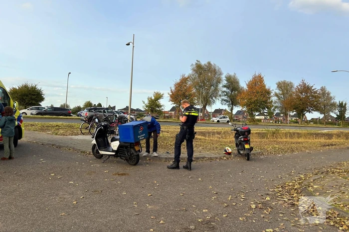 Bezorger op scooter en scooterrijder botsen op elkaar