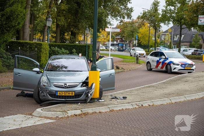 Automobilist ramt verkeersbord en lantaarnpaal
