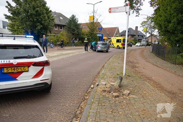 Automobilist ramt verkeersbord en lantaarnpaal