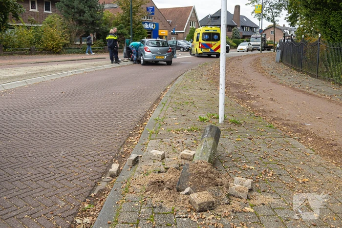 Automobilist ramt verkeersbord en lantaarnpaal