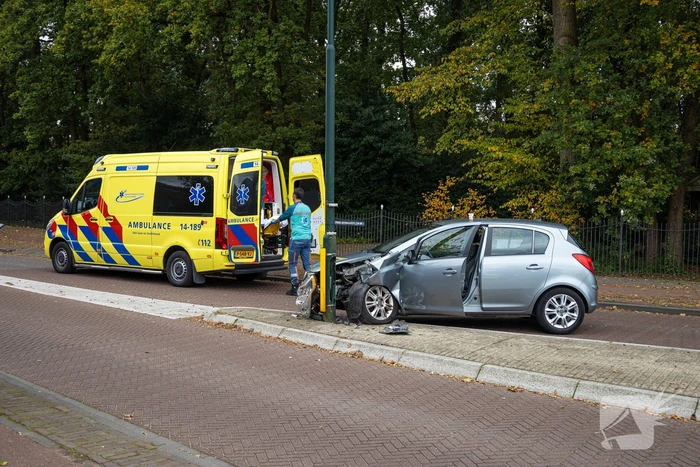 Automobilist ramt verkeersbord en lantaarnpaal