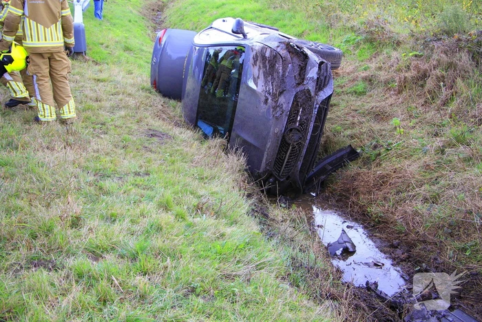 Personenauto belandt op de zijkant in sloot