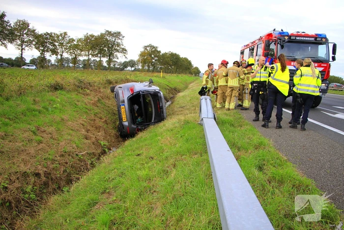 Personenauto belandt op de zijkant in sloot