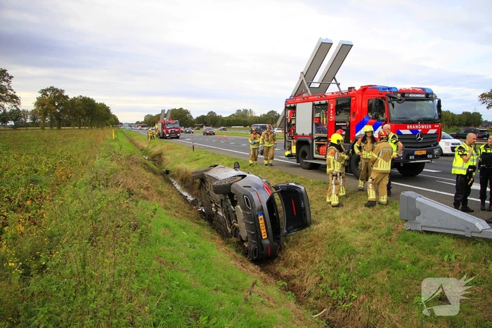 Personenauto belandt op de zijkant in sloot