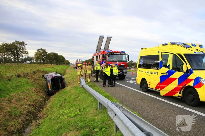 Personenauto belandt op de zijkant in sloot