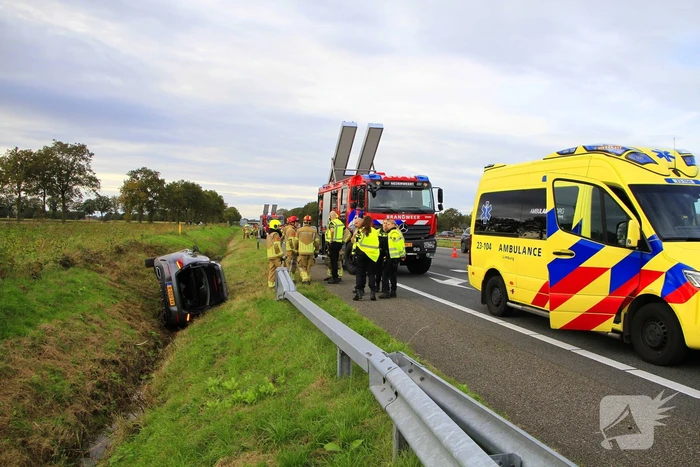Personenauto belandt op de zijkant in sloot