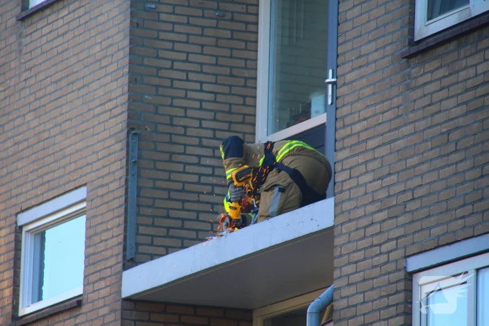 Persoon door hijskraan uit flatwoning getakeld