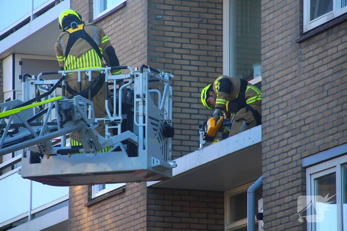 Persoon door hijskraan uit flatwoning getakeld