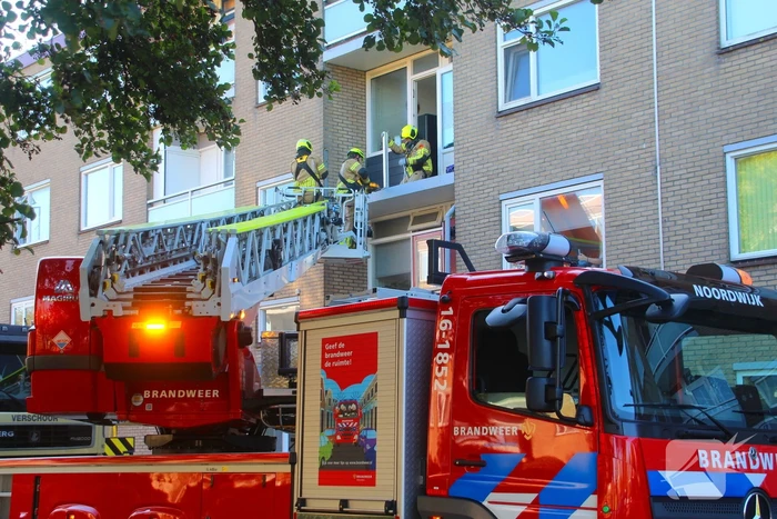 Persoon door hijskraan uit flatwoning getakeld