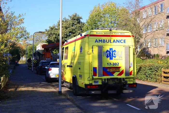 Persoon door hijskraan uit flatwoning getakeld