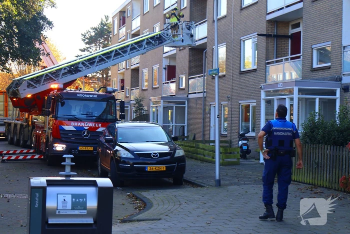 Persoon door hijskraan uit flatwoning getakeld